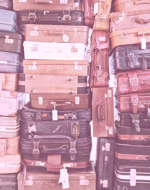 Dozens of vintage suitcases stacked on top of each other