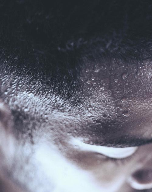 Close up image of sweat running down a man's forehead