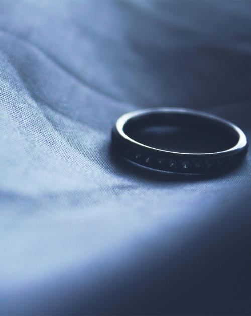 A wedding ring sits on a wrinkled piece of cloth